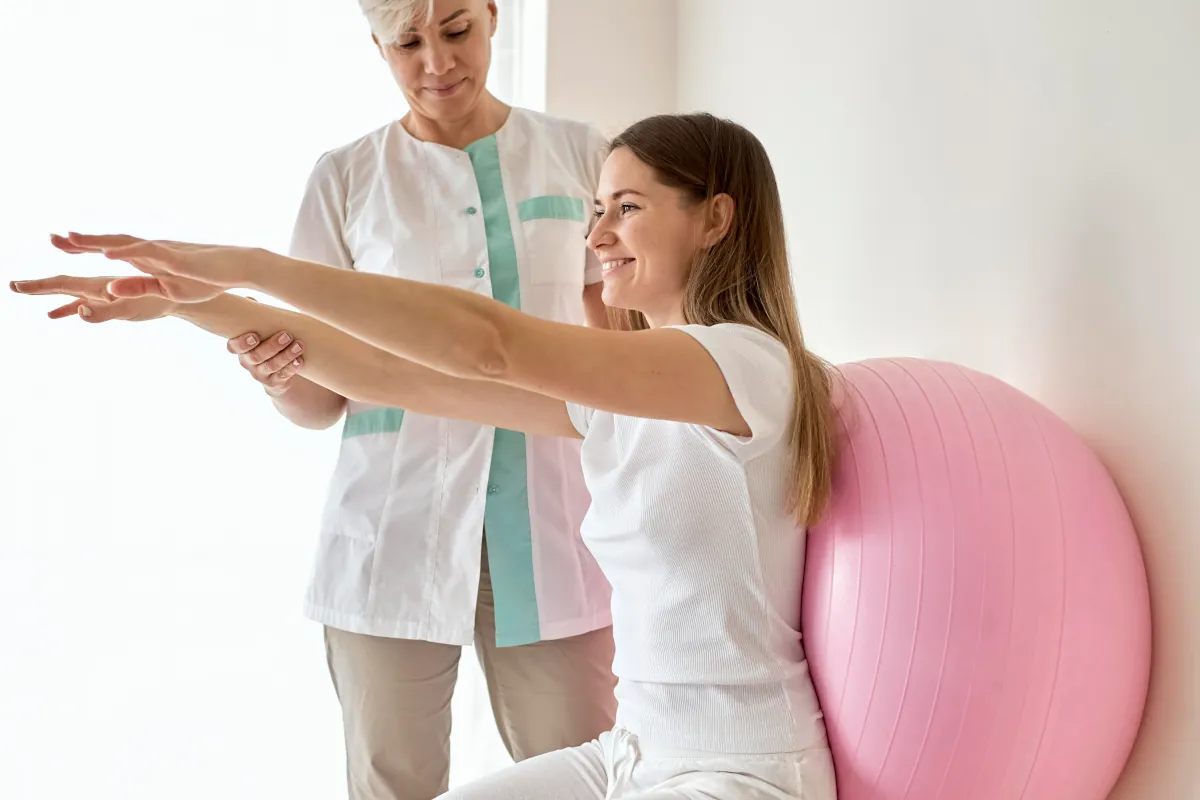 Fisioterapeuta atendendo paciente e usando notebook para gerenciar presença digital