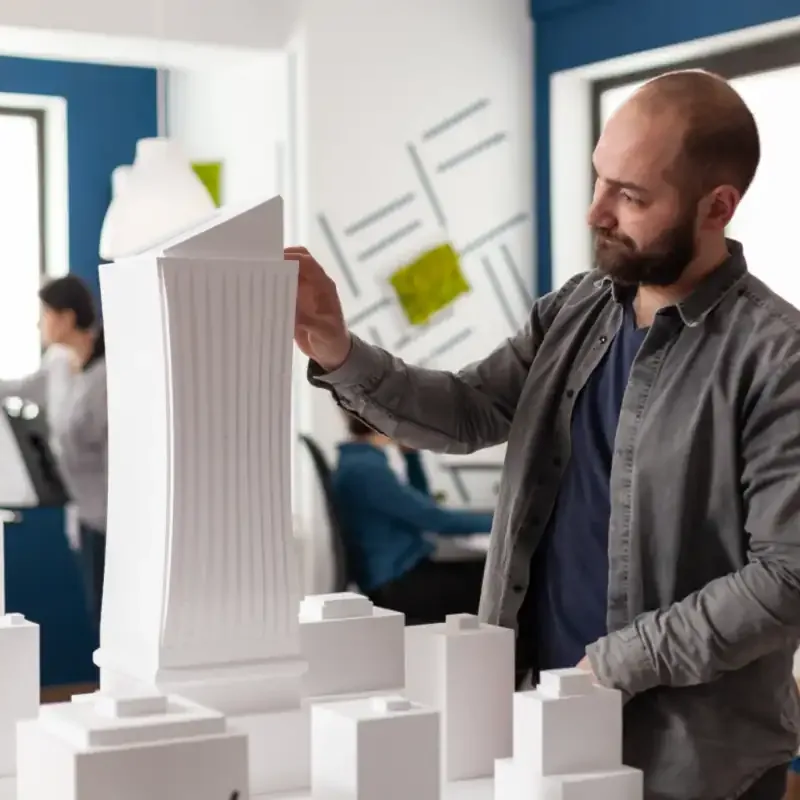 Profissional analisando a maquete de um prédio