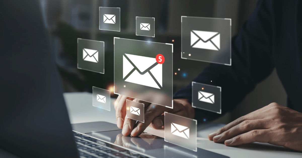 Pessoa usando notebook com ícones de e-mail em volta da tela, um deles com notificação de 5 novas mensagens